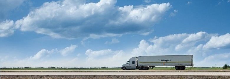 Semi Truck Driving With Clouds In The Background.